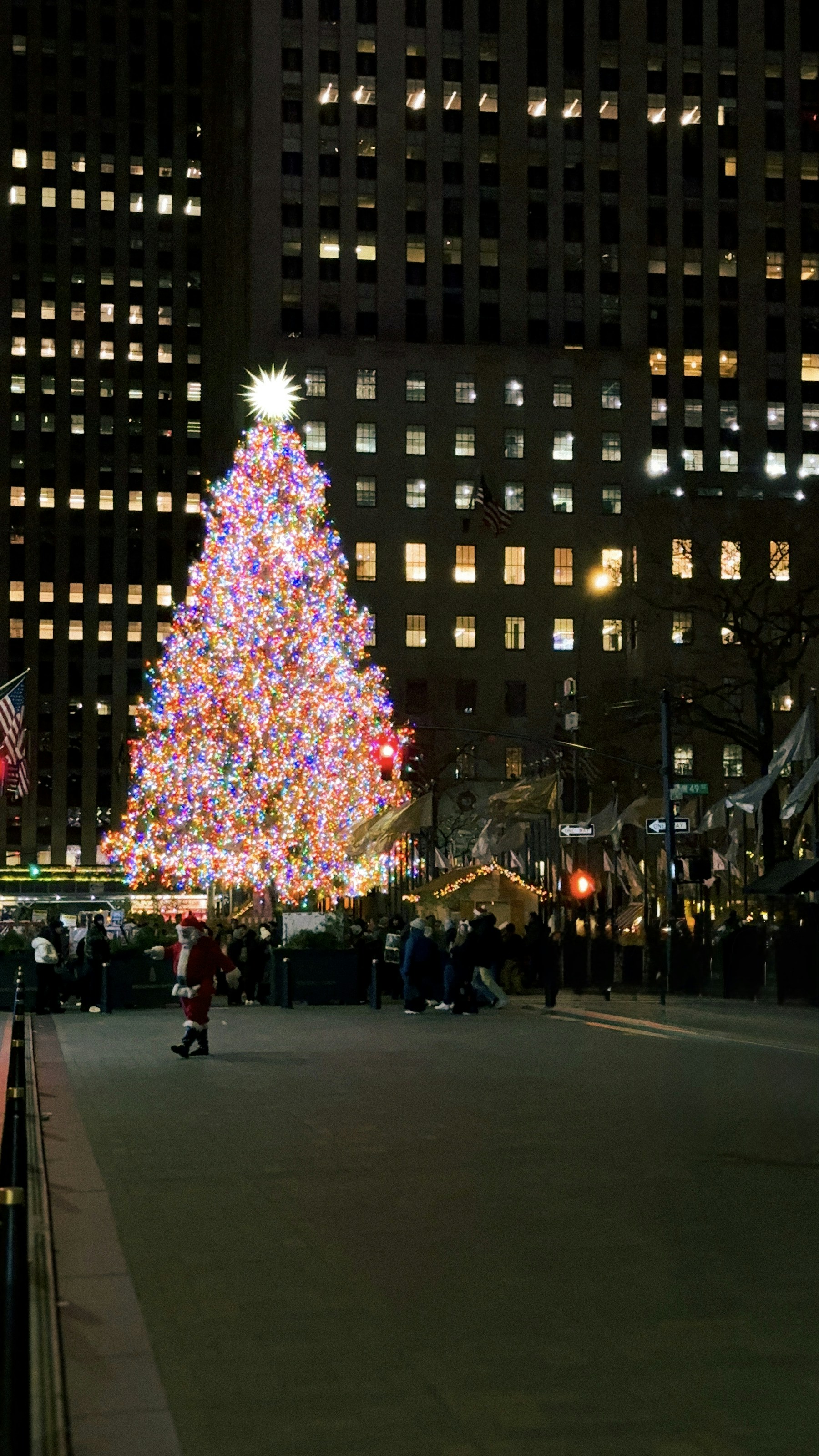 The Rockefeller Center Christmas tree glowing with colorful holiday lights at night in New York City